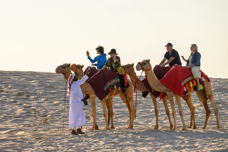 Touristes sur des chameaux au Qatar